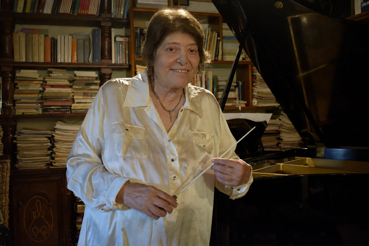 Antonella Barbarossa accanto al pianoforte con la bacchetta da direttrice